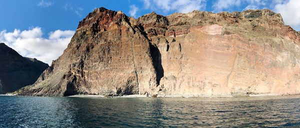 Rock formations by sea against sky