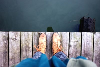 Low section of man standing on wood
