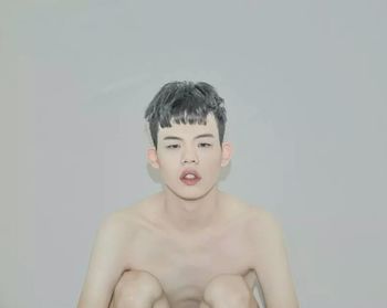 Portrait of shirtless boy against white background