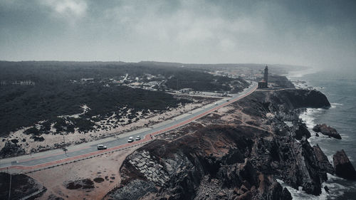 Aerial view of road by sea against sky