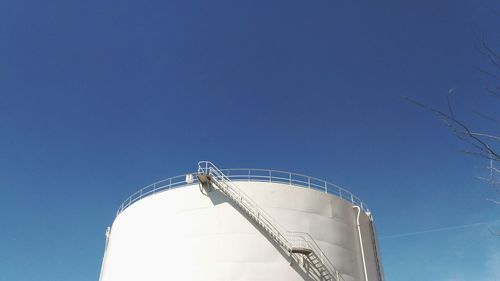Low angle view of silo against clear blue sky