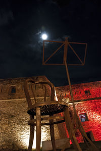 Illuminated lamp against sky at night