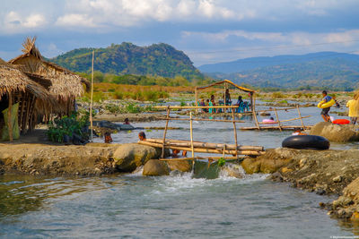 People enjoying in river against mountains