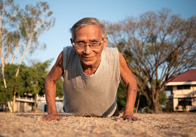 Portrait of man in park against sky