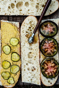 White bread baguette slices with mustard, pickles, honey on black heirloom tomato slices sandwich 