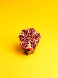 Close-up of pomegranate against yellow background