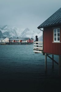 Man standing on balcony looking at view over lake during winter