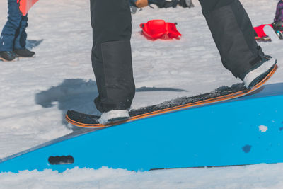 A close-up shot of a caucasian man sliding down a slope on a snow skate at a ski resort in france