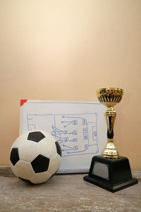 Close-up of soccer ball with award and whiteboard on table