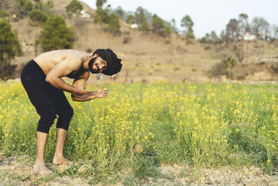 Young indian farmer working in the fields, growing crops. farming and agriculture concept.