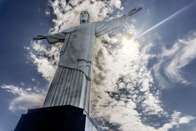 Low angle view of cross sculpture against building