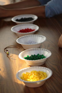 High angle view of various beads in bowls on table