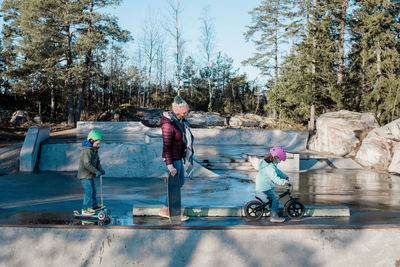 Mom and her kids riding in a skatepark having fun in the sunshine