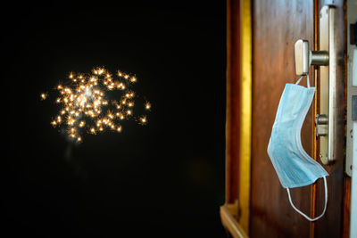 Illuminated lighting equipment hanging on wall at home