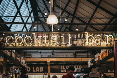 Low angle view of illuminated pendant lights hanging from ceiling