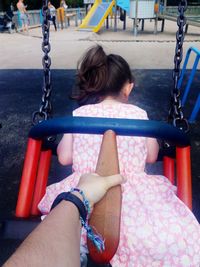 Girl sitting on swing in park