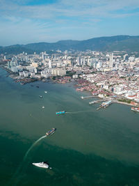 High angle view of city by sea against sky