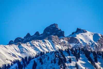 Panoramic view of snowcapped mountains against clear blue sky