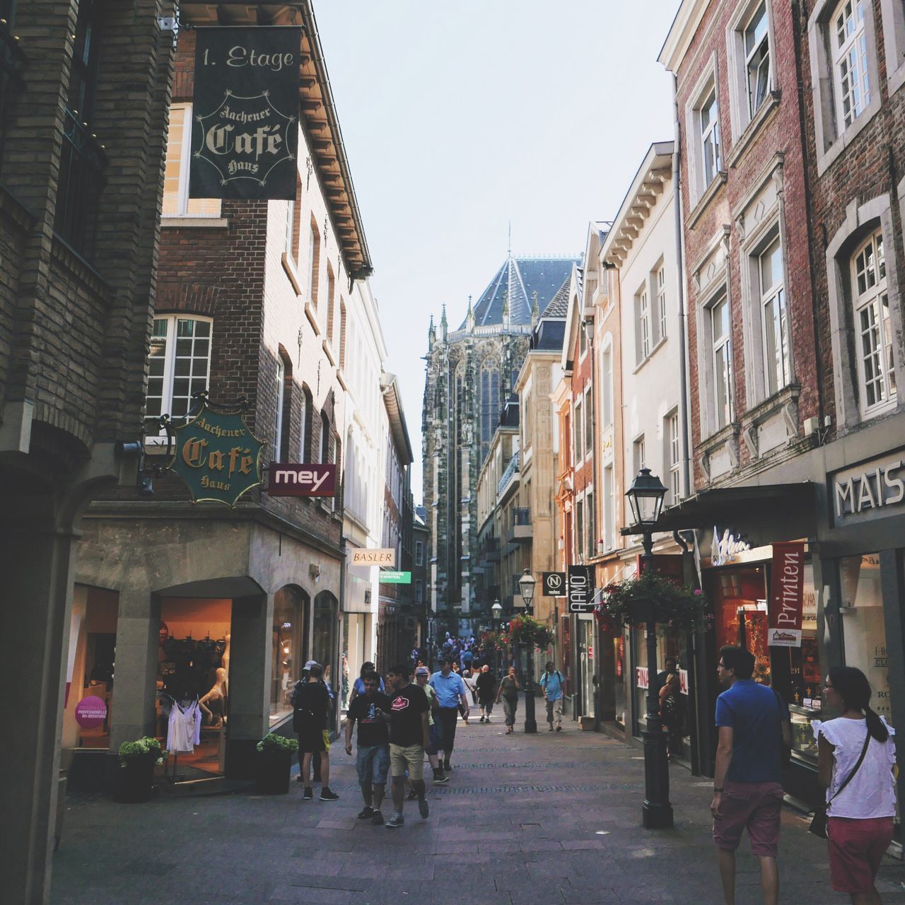 PEOPLE WALKING ON STREET AGAINST BUILDINGS