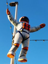 Low angle view of person against blue sky