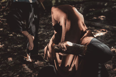 Midsection of woman standing on field in forest