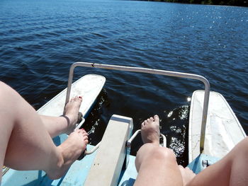 Low section of people on pedal boat in sea