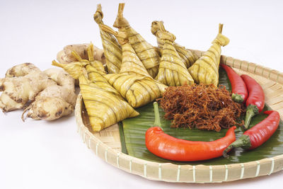 High angle view of meat and leaves on white background