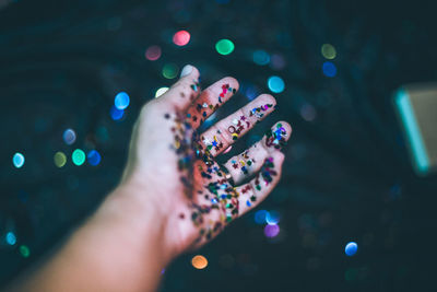 Close-up of hand holding multi colored confetti