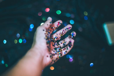 Close-up of hand holding multi colored lights