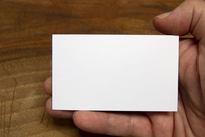 Midsection of person holding paper