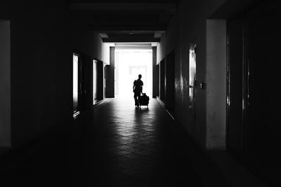 Rear view of silhouette man walking in corridor of building