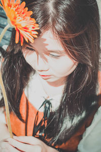 Close-up of beautiful young woman holding flower