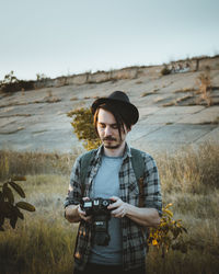 Young man photographing on field