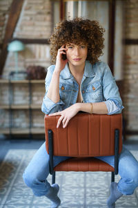 Portrait of young woman sitting on chair