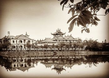 Reflection of building in lake against clear sky