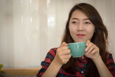 Portrait of young woman drinking coffee