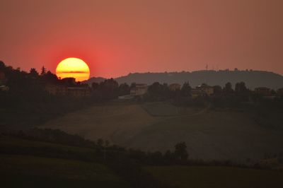 Scenic view of field against orange sky