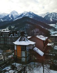 Built structure on snow covered mountains against sky