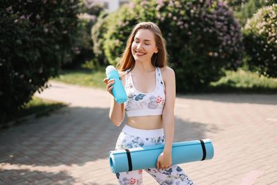 Athletic happy healthy young woman in sportswear goes after a sports workout exercise in nature