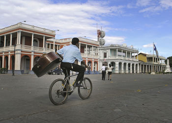 Rear view of man riding bicycle in city