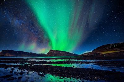 Scenic view of star constellation and aurora over landscape 