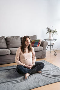 Woman sitting on sofa at home