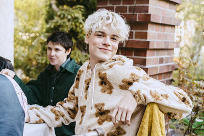 Portrait of smiling gay man with white hair during dinner party in back yard