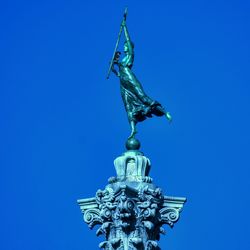 Low angle view of statue against blue sky