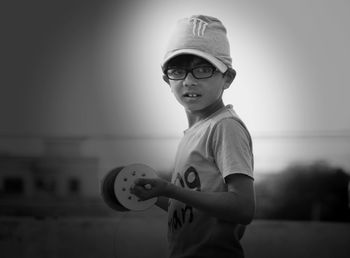 Portrait of boy standing against wall