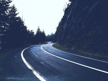Road amidst trees against clear sky