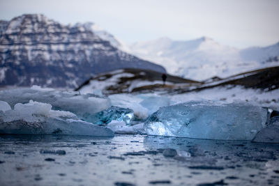 Surface level of frozen lake against mountain during winter