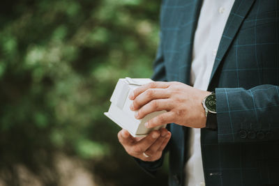 Man in a suit opening a present in a gift box