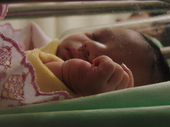 Close-up of cute baby sleeping in crib