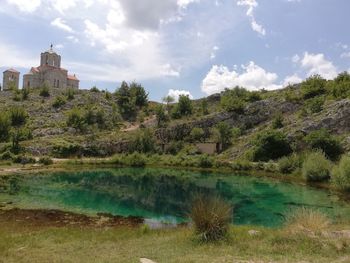 Scenic view of lake by buildings against sky